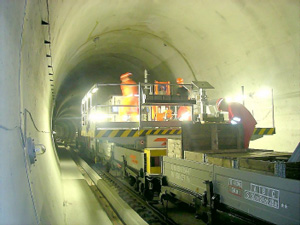 Castillete operando sobre vagón en el interior de un túnel, con las plataformas laterales parcialmente desplegadas.